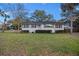 Charming single-story home with white brick exterior, shutters, and a well-manicured front lawn at 3304 Hartnett Blvd, Isle of Palms, SC 29451