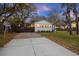 Exterior view showcasing a charming home with a gravel driveway, lush trees, and a cozy ambiance with inviting curb appeal at 3304 Hartnett Blvd, Isle of Palms, SC 29451