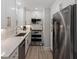 Modern galley kitchen featuring stainless steel appliances, white cabinets, and light countertops at 3304 Hartnett Blvd, Isle of Palms, SC 29451