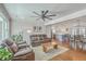 Open living room with leather sofas, ceiling fan, and an open floor plan flowing into the kitchen and dining area at 3552 Old Ferry Rd, Johns Island, SC 29455