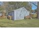 A quaint backyard shed stands beside stacked firewood on a lush lawn at 3552 Old Ferry Rd, Johns Island, SC 29455