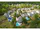 Aerial view of a residential neighborhood, showcasing homes, lush trees, and community swimming pools at 4029 Cascades Thrust, Summerville, SC 29483