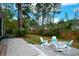 Backyard with fire pit, Adirondack chairs, lush landscaping, and patio is a perfect outdoor space at 4029 Cascades Thrust, Summerville, SC 29483