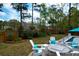 Backyard with fire pit, Adirondack chairs, and lush landscaping creates a serene outdoor space at 4029 Cascades Thrust, Summerville, SC 29483