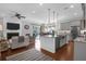 Open-concept living room and kitchen with an island, stainless steel appliances, and wood flooring, perfect for entertaining at 4029 Cascades Thrust, Summerville, SC 29483