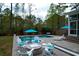 Backyard pool and patio area with fire pit, Adirondack chairs, and serene green space offers an inviting outdoor oasis at 4029 Cascades Thrust, Summerville, SC 29483