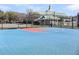 Community's basketball court with blue and red surface and backdrop of clubhouse and green landscape at 412 Hydrangea St, Summerville, SC 29483
