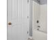 Bathroom with a shower and bathtub, and a white tiled wall. A white door with brass hardware is in the image at 412 Hydrangea St, Summerville, SC 29483