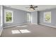 Spacious bedroom with neutral carpet, ceiling fan, and natural light from large windows at 412 Hydrangea St, Summerville, SC 29483