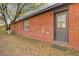 Red brick exterior with a black door, window, and minimal landscaping at 4418 Hardwood St, Ladson, SC 29456