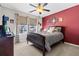 Comfortable bedroom features a ceiling fan, large windows, and a charming red accent wall at 449 Whispering Breeze Ln, Summerville, SC 29486