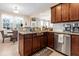 Bright kitchen area features granite countertops, brown cabinets, and stainless steel dishwasher at 449 Whispering Breeze Ln, Summerville, SC 29486