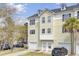 Three-story townhome with light yellow siding, one car garage, and driveway with parked car at 4512 Great Oak Dr, North Charleston, SC 29418