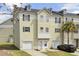 Three-story townhome with one car garage, light yellow siding, and black shutters at 4512 Great Oak Dr, North Charleston, SC 29418