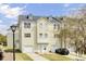 A view of a two-story townhome with one car garage, light yellow siding, and black shutters at 4512 Great Oak Dr, North Charleston, SC 29418