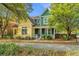 Charming yellow and green two-story home with a cozy front porch surrounded by lush landscaping at 5132 E Liberty Park Cir, North Charleston, SC 29405