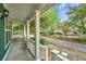 Inviting front porch with classic white columns offering a serene view of the street and foliage at 5132 E Liberty Park Cir, North Charleston, SC 29405
