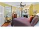 Bedroom with hardwood floors, a four-poster bed, ceiling fan, fireplace, and lots of natural light at 516 Central Ave, Summerville, SC 29483