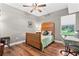 A quaint bedroom featuring hardwood floors, a comfortable bed, and natural light from the window at 516 Central Ave, Summerville, SC 29483