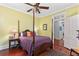 Bedroom with hardwood floors, a four-poster bed, ceiling fan, side table and view of ensuite bathroom at 516 Central Ave, Summerville, SC 29483