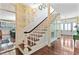 Grand entryway featuring a staircase with white railings, wood floors, and decorative wallpaper at 516 Central Ave, Summerville, SC 29483