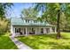 Exterior of a home featuring a green metal roof, white siding, and a wide porch at 516 Central Ave, Summerville, SC 29483