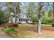 Charming two-story traditional home with a welcoming front porch, lush landscaping, and mature trees at 516 Central Ave, Summerville, SC 29483