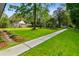 Well-maintained front yard with lush grass, mature trees, and a sidewalk leading to the house at 516 Central Ave, Summerville, SC 29483