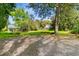 Front yard with a driveway, lush lawn, mature trees, and a view of the house at 516 Central Ave, Summerville, SC 29483