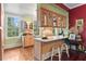 Charming kitchen with a breakfast bar, glass-front cabinets, and refinished hardwood floors at 516 Central Ave, Summerville, SC 29483