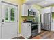 Bright kitchen featuring white cabinets, stainless steel appliances, and a view to the outdoors at 516 Central Ave, Summerville, SC 29483