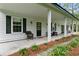 Inviting porch with white columns, a seating area, and views of the landscaped yard at 516 Central Ave, Summerville, SC 29483