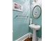 Stylish powder room featuring a pedestal sink, oval mirror, and light blue walls at 516 Central Ave, Summerville, SC 29483