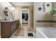 Well-lit bathroom with double sinks, a large soaking tub, and a view into the walk-in closet at 5509 Alpine Dr, Summerville, SC 29483