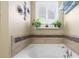 Relaxing bathtub area with decorative plants and a tiled accent wall for added ambiance at 5509 Alpine Dr, Summerville, SC 29483