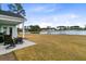 Expansive backyard with a covered patio, outdoor seating, and beautiful lake views at 552 Marsh Cv Cir, Summerville, SC 29486