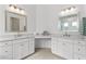 Bright bathroom with dual vanity sinks, marble countertops, and white cabinetry at 552 Marsh Cv Cir, Summerville, SC 29486