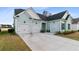 Three car garage featuring carriage doors, black hardware and well manicured landscaping at 552 Marsh Cv Cir, Summerville, SC 29486