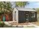 Modern backyard house with sleek gray siding and a metal roof, surrounded by greenery and stepping stones at 639 Bridlewood Ln, Mount Pleasant, SC 29464