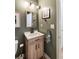 Cozy half bath with wood vanity, white countertop, modern fixtures, and olive green walls at 639 Bridlewood Ln, Mount Pleasant, SC 29464