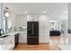 Well-lit kitchen with stainless steel fridge, white cabinets, and hardwood floors extending into living room at 639 Bridlewood Ln, Mount Pleasant, SC 29464