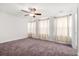Bedroom features a ceiling fan, carpet, three windows with coverings, and neutral paint at 7787 Montview Rd, North Charleston, SC 29418