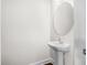 Modern powder room with a pedestal sink and a round mirror, showcasing a clean and minimalist design at 7787 Montview Rd, North Charleston, SC 29418