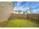 Backyard features a wooden fence, green grass, and shade from trees to provide privacy at 7818 Expedition Dr, North Charleston, SC 29420