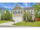 Charming two-story home featuring a well-manicured lawn, neutral siding, black shutters, and an attached two-car garage at 7818 Expedition Dr, North Charleston, SC 29420