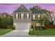 Charming two-story home featuring a well-manicured lawn, neutral siding, black shutters, and an attached two-car garage at 7818 Expedition Dr, North Charleston, SC 29420