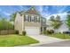 Charming two-story home featuring a well-manicured lawn, neutral siding, black shutters, and an attached two-car garage at 7818 Expedition Dr, North Charleston, SC 29420