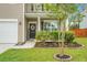 Charming front door with a decorative wreath, 'WELCOME' sign, and attractive landscaping featuring lush greenery and red flowers at 7818 Expedition Dr, North Charleston, SC 29420