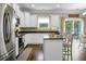 Bright kitchen features stainless appliances, a center island with seating, and a dining area with backyard access at 7818 Expedition Dr, North Charleston, SC 29420