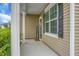 Inviting front porch with white columns, a 'WELCOME' sign, large windows with black shutters, and neutral siding at 7818 Expedition Dr, North Charleston, SC 29420